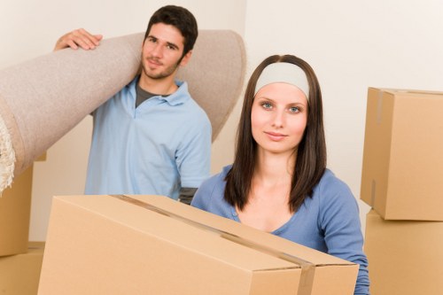 Professional team handling furniture pick-up from a narrow staircase in Belsize Park